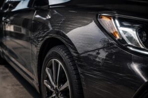 Car with visible scratches and scuff marks on the side panel.