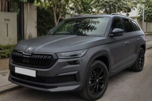 A dark grey SUV with a satin matte finish parked in soft natural light, close enough to show the non-reflective texture clearly, clean urban Bangalore backdrop with greenery, photorealistic.