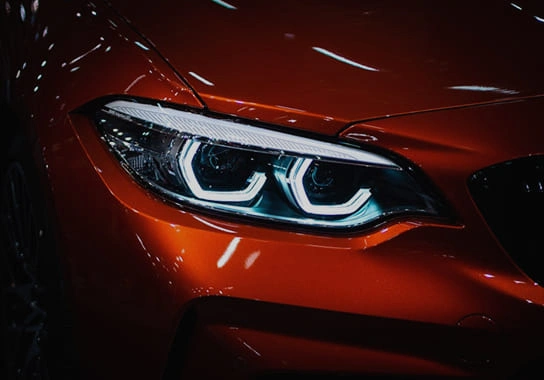 Close-up of a new car headlight and paint finish