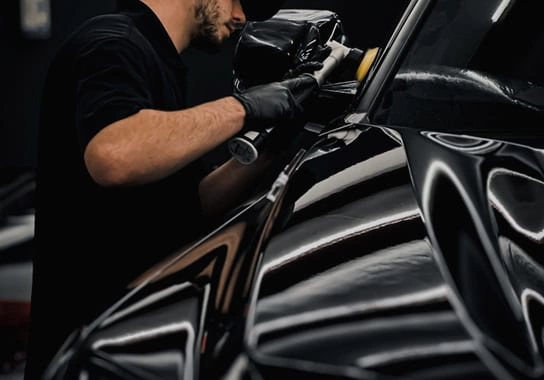 A detailing specialist applying PPF to a vehicle